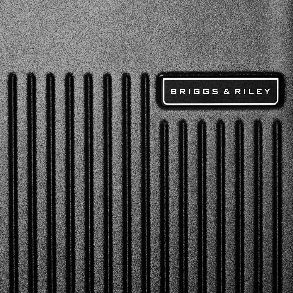 Black 86cm extra large spinner suitcase from Briggs & Riley Sympatico 3.0, featuring four wheels and a sleek design.