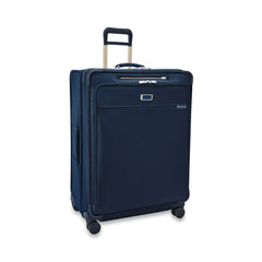 Extra large expandable spinner suitcase in navy by Briggs & Riley, featuring four wheels and sturdy handle for easy transport.