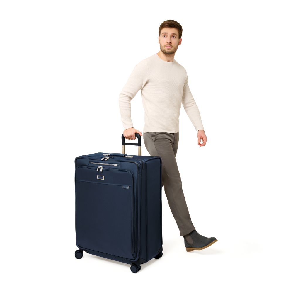 Extra large expandable spinner suitcase in navy from Briggs & Riley, featuring durable wheels and spacious interior.