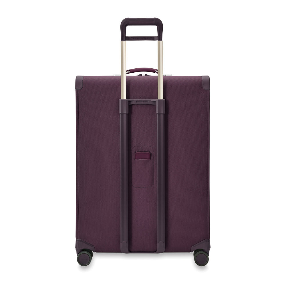 Extra large expandable spinner suitcase in plum color from Briggs & Riley, featuring dual wheels and sturdy handles.