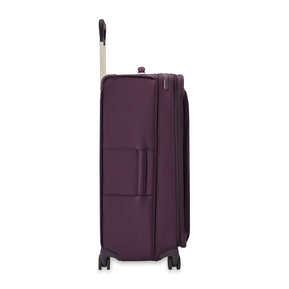 Extra large expandable spinner suitcase in plum by Briggs & Riley, showcasing durable design and smooth-rolling wheels.