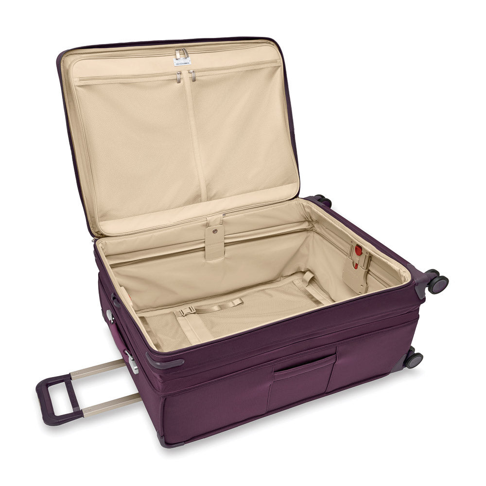 Extra large expandable spinner suitcase in plum, featuring Briggs & Riley luggage design and durable wheels for easy travel.