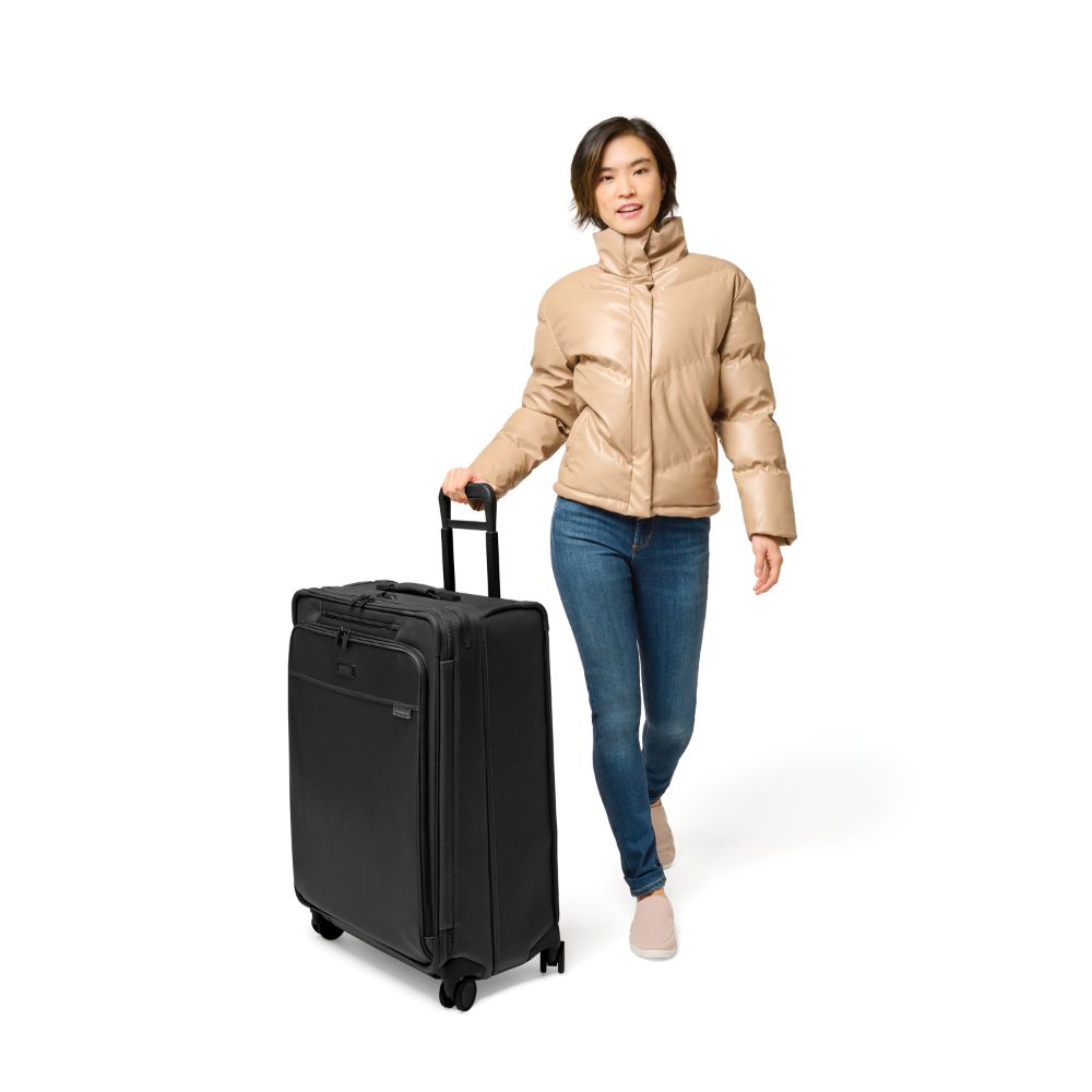 Large expandable spinner suitcase in black by Briggs & Riley, featuring four wheels and a sturdy handle for easy travel.