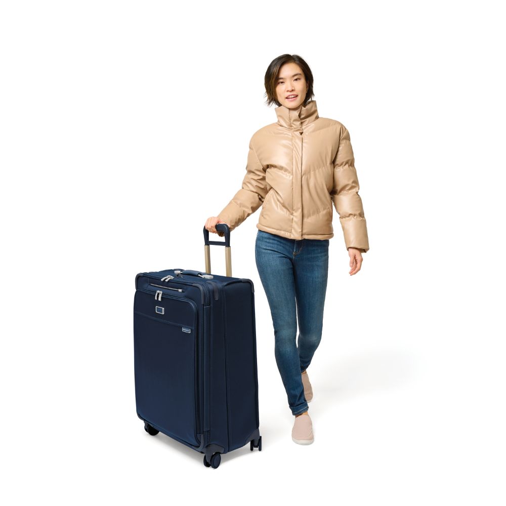 Large expandable spinner suitcase in navy by Briggs & Riley, featuring durable material and smooth-rolling wheels.