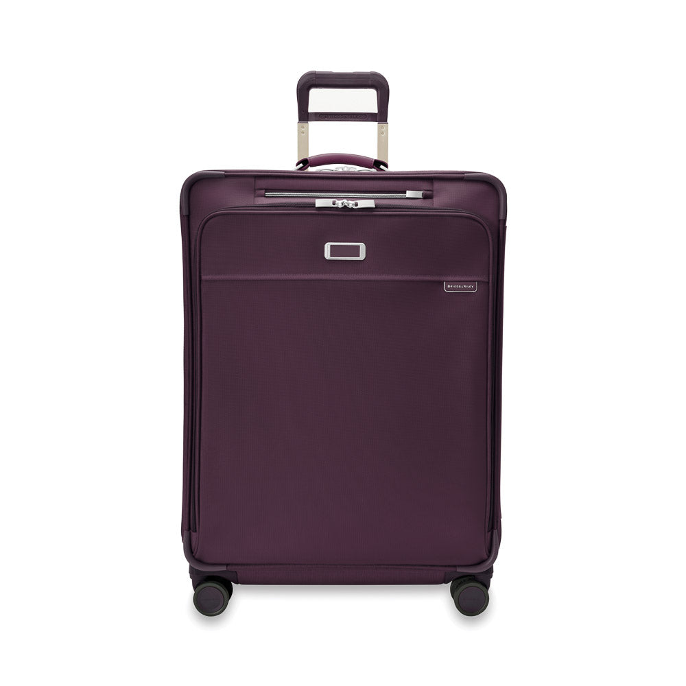 Large expandable spinner suitcase in plum by Briggs & Riley, featuring four wheels and a durable design for check-in luggage.