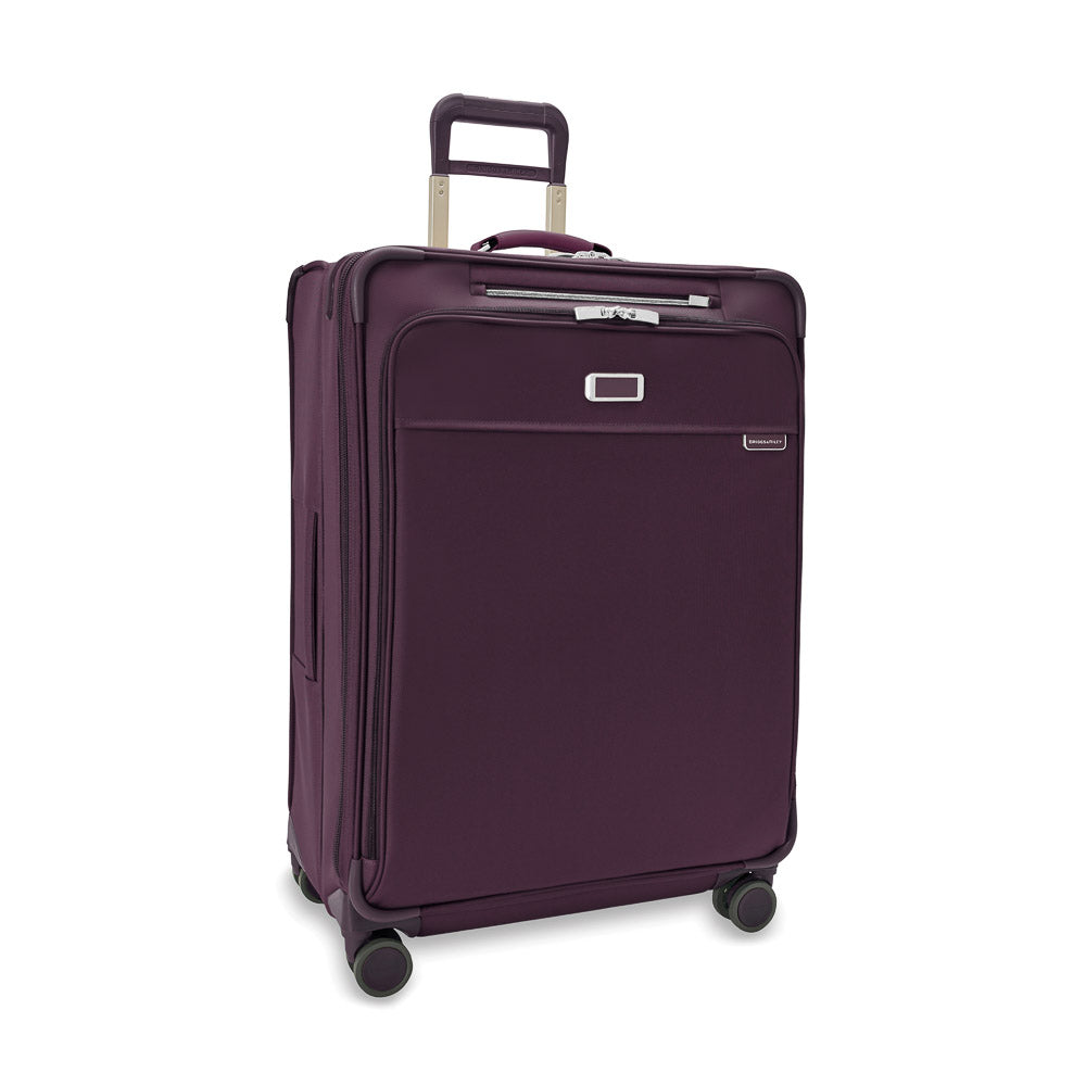 Large expandable spinner suitcase in plum by Briggs & Riley, featuring smooth wheels and a spacious interior for check-in travel.