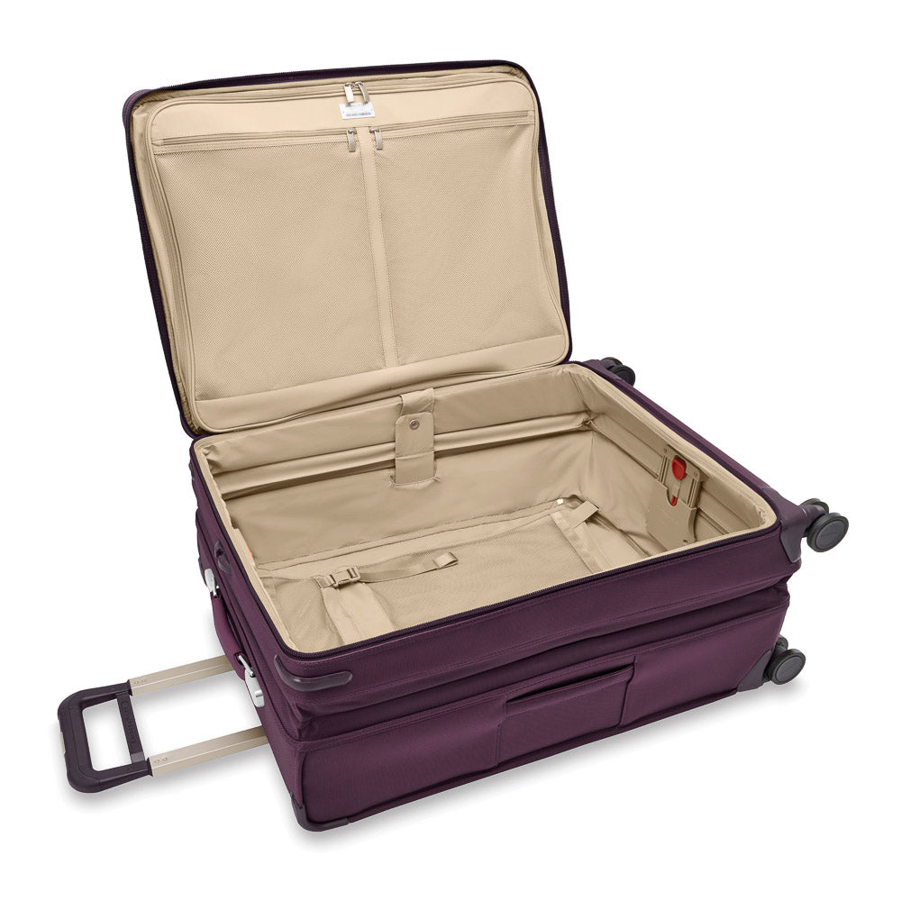 Briggs & Riley Baseline 2 large expandable spinner suitcase in plum color, featuring wheels and sturdy handles for easy travel.
