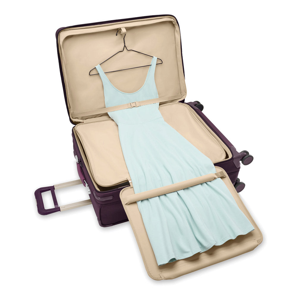 Large expandable spinner suitcase in plum from Briggs & Riley, showcasing durable exterior and spacious interior.