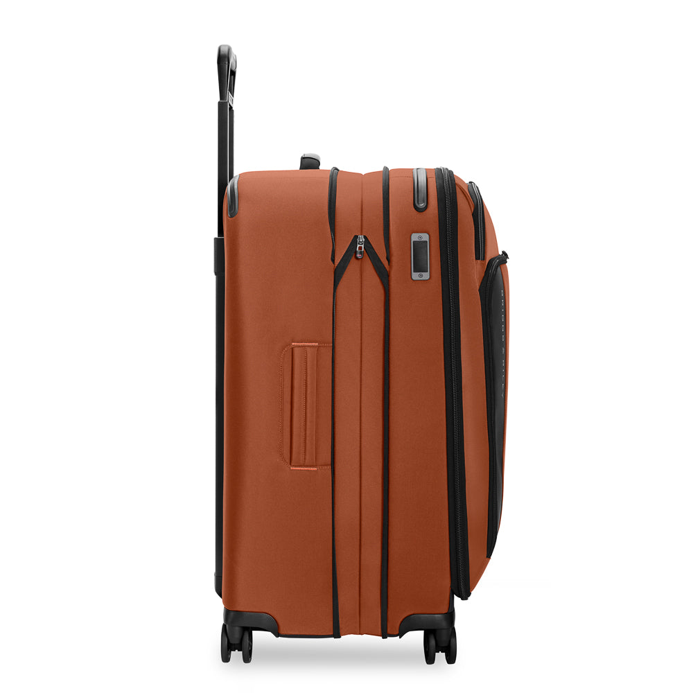 Large expandable spinner suitcase by Briggs & Riley in canyon color, showcasing four wheels and spacious interior.