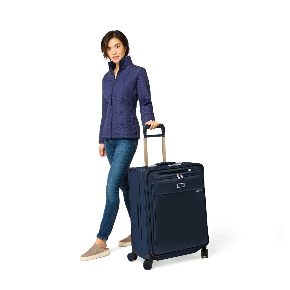 Briggs & Riley Baseline 2 medium expandable spinner suitcase in navy blue, featuring smooth wheels and durable design.