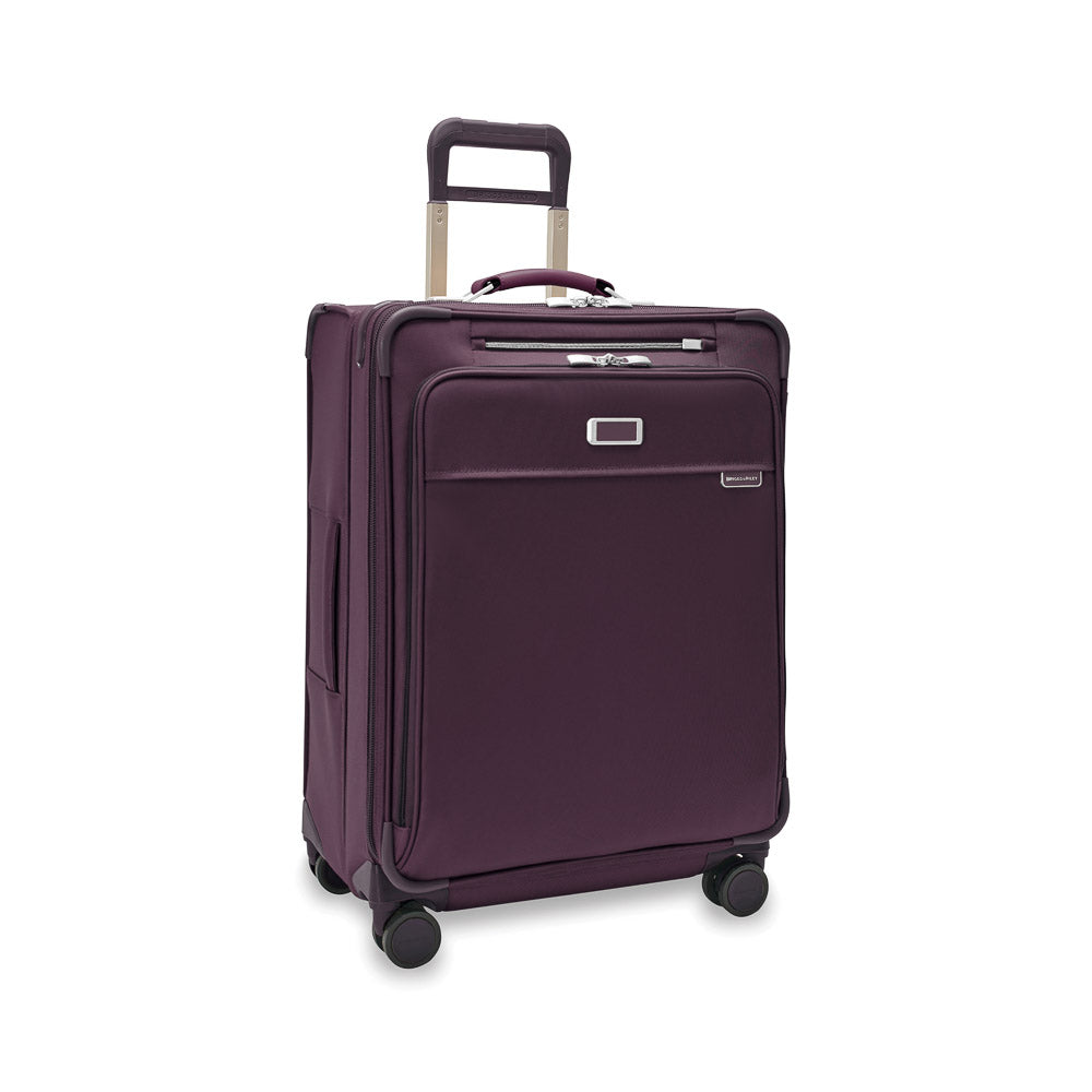 Briggs & Riley Baseline 2 medium expandable spinner suitcase in plum, featuring smooth wheels and a sturdy handle.
