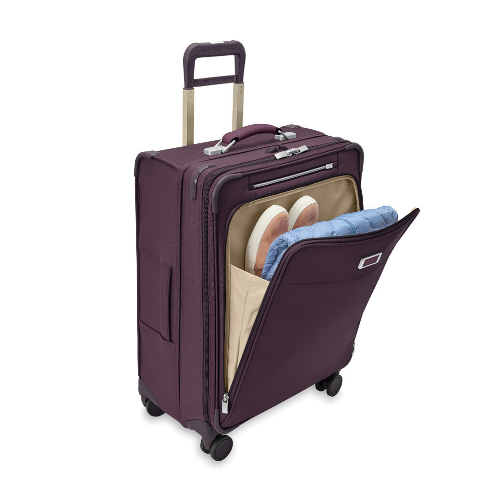 Medium expandable spinner suitcase in plum by Briggs & Riley, featuring durable wheels and spacious interior for travel.