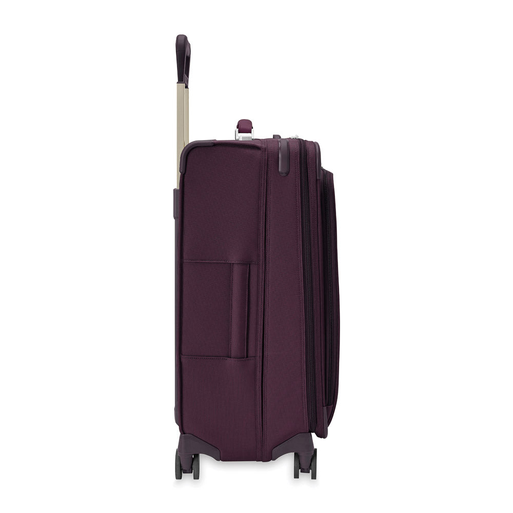 Plum medium expandable spinner suitcase by Briggs & Riley, showcasing a sleek design and durable exterior.