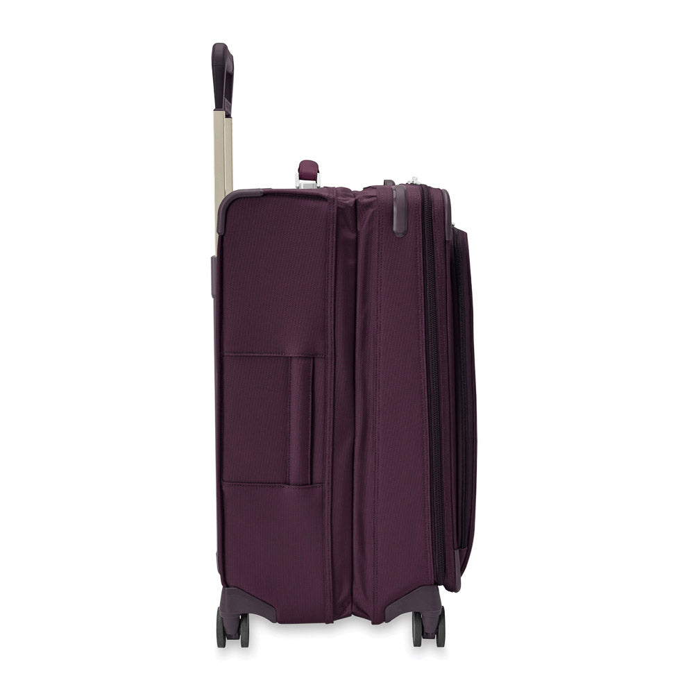 Briggs & Riley Baseline 2 medium expandable spinner suitcase in plum color with wheels and handle for easy transport.