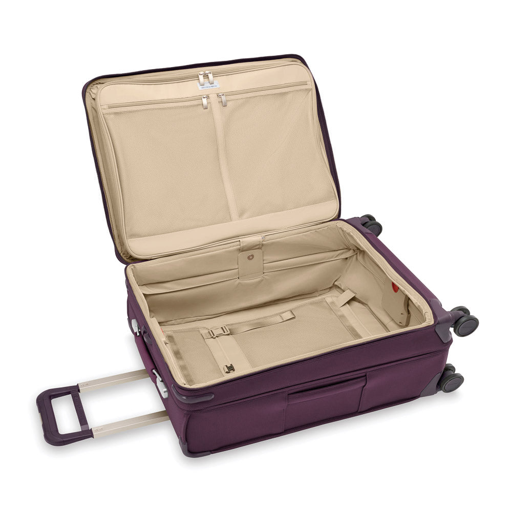 Medium expandable spinner suitcase in plum by Briggs & Riley, featuring durable wheels and spacious interior for travel.