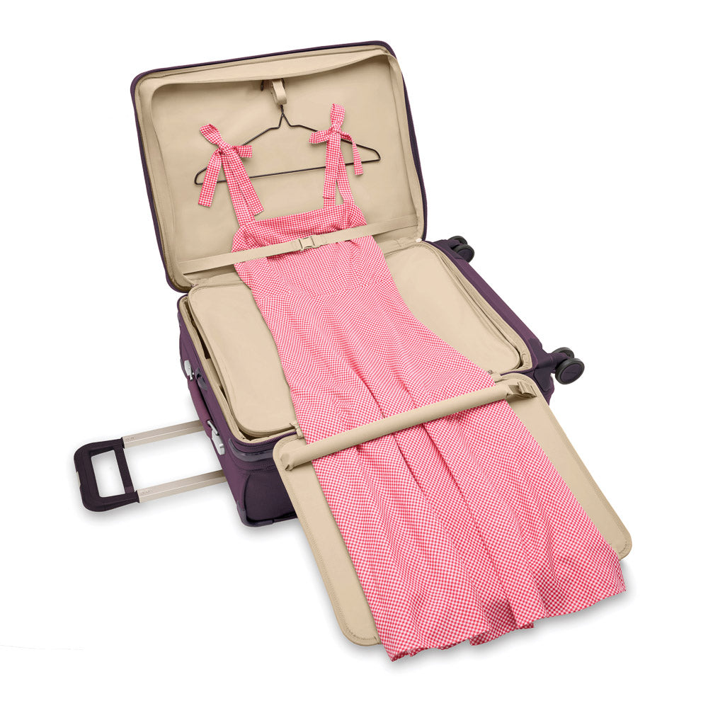 Medium expandable spinner suitcase in plum by Briggs & Riley, featuring smooth wheels and a durable exterior.