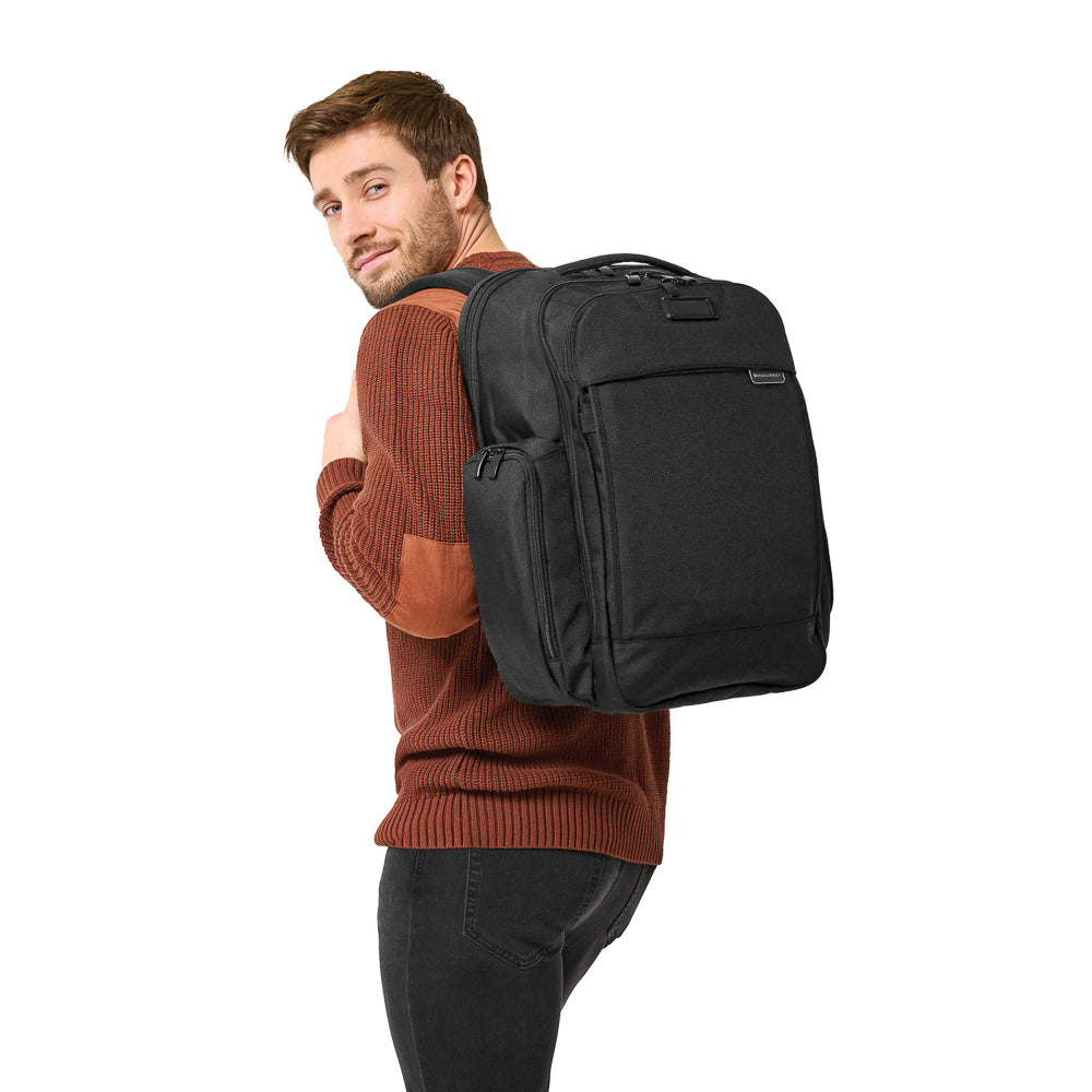 Black Briggs & Riley Baseline 2 travel backpack with multiple compartments and padded straps for comfort.